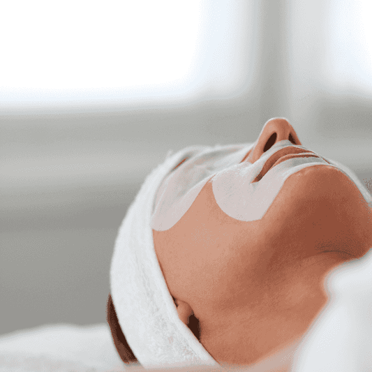 Femme allongée avec un bandeau de démaquillage et des patchs pour les yeux, accessoire pour soins visage.