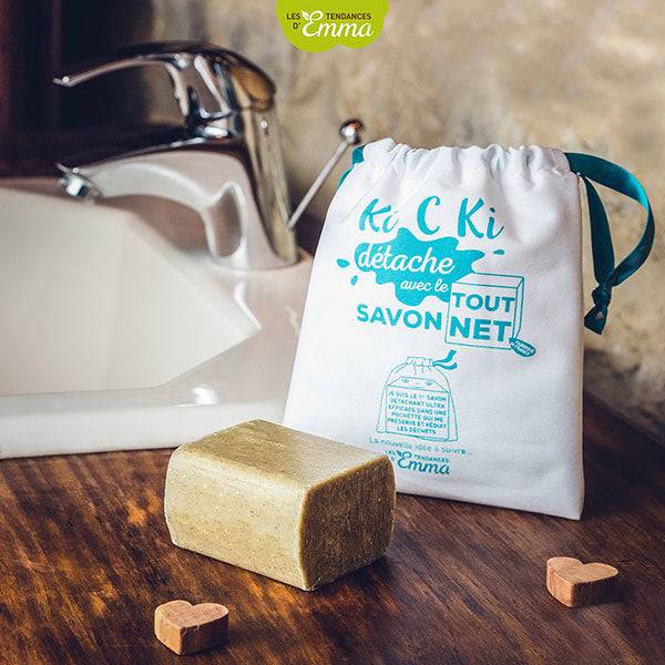 Kit savon détachant solide avec pochette blanche près d'un lavabo, conçu pour éliminer efficacement les tâches.
